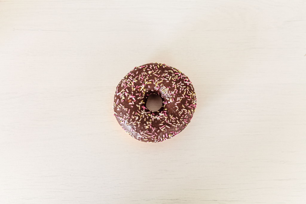 A chocolate covered donut with sprinkles